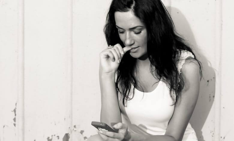 Woman-Checking-Smartphone-while-biting-nail-body-language-mistake
