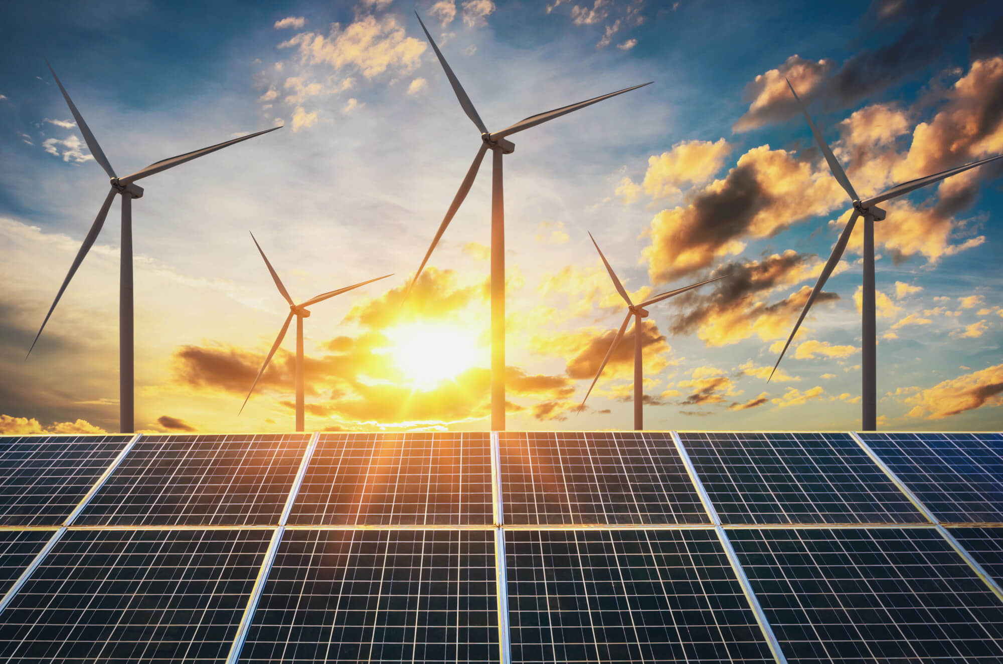 wind turbine with solar panels and sunset